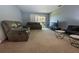 Comfortable living room with plush seating, neutral carpet, and access to an outdoor balcony at 1695 Lee Rd # E215, Winter Park, FL 32789