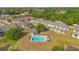 Aerial view of the community pool and deck surrounded by lush landscaping and townhome complexes at 1773 Barton Towne Cir, St Cloud, FL 34769