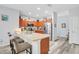 Open-concept kitchen with stainless steel appliances, breakfast bar, and wood floors at 1773 Barton Towne Cir, St Cloud, FL 34769