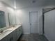 Contemporary bathroom featuring double vanity sinks, neutral tile, and glass door shower at 1796 Foreman Rd, Eagle Lake, FL 33839