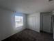 A simple bedroom features a window for natural light, carpeting, and a closet for storage at 1796 Foreman Rd, Eagle Lake, FL 33839