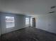 A carpeted bedroom with a window, and access to additional rooms within the home at 1796 Foreman Rd, Eagle Lake, FL 33839