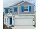 Charming two-story home features a gray facade with bright blue shutters and a white garage door at 1796 Foreman Rd, Eagle Lake, FL 33839