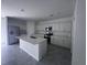 A view of a spacious kitchen featuring a center island, stainless steel appliances, and white cabinets and countertops at 1796 Foreman Rd, Eagle Lake, FL 33839