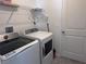 A laundry room features a full sized washer and dryer and metal shelving for storage at 1796 Foreman Rd, Eagle Lake, FL 33839