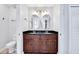 Bathroom showcasing double sinks, dark countertops, and a door that offers convenient access to the facilities at 199 Maple Dr, Kissimmee, FL 34759