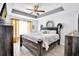 Bedroom featuring a tray ceiling, wood furniture, and natural light at 199 Maple Dr, Kissimmee, FL 34759