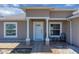 Inviting front porch with two chairs and a small table between white columns and fresh landscaping at 199 Maple Dr, Kissimmee, FL 34759