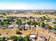 Aerial view of homes with tree-lined neighborhood and buildings in the distance at 1930 Knollcrest Dr, Clermont, FL 34711