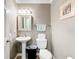 Well-kept half bathroom featuring a decorative mirror, pedestal sink, and neutral wall color at 1930 Knollcrest Dr, Clermont, FL 34711