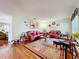 Bright living room with hardwood floors, leather sofas, area rug, and tasteful décor creating a warm ambiance at 1930 Knollcrest Dr, Clermont, FL 34711