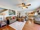 Well-lit living room leading into a dining area, featuring hardwood floors and comfortable sofas at 1930 Knollcrest Dr, Clermont, FL 34711