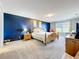 A tranquil main bedroom features a bold accent wall, soft carpeting, and natural light at 1930 Knollcrest Dr, Clermont, FL 34711