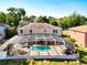 Rear of property featuring a screened pool area with pool, hot tub, and grill at 1930 Knollcrest Dr, Clermont, FL 34711