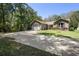 Charming single Gathering home featuring a long driveway, two-car garage, and manicured lawn at 2074 King Richards Ct, Orange City, FL 32763