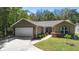 Charming single-story home boasts a manicured lawn, mature landscaping and an attached two-car garage at 2074 King Richards Ct, Orange City, FL 32763