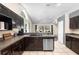 Well-lit kitchen featuring dark cabinets, stainless steel appliances, and granite countertops at 2074 King Richards Ct, Orange City, FL 32763