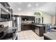Well-equipped kitchen with dark cabinetry, stainless steel appliances, and tile backsplash at 2074 King Richards Ct, Orange City, FL 32763