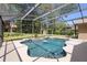 Screened-in pool features updated tile, hardscape, and newer equipment, all surrounded by lush landscaping at 2074 King Richards Ct, Orange City, FL 32763