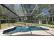 Screened-in pool area featuring a waterfall feature, surrounded by lush landscaping and a privacy fence at 2074 King Richards Ct, Orange City, FL 32763