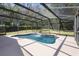 Screened-in pool area featuring a waterfall feature and an expansive patio, perfect for outdoor enjoyment at 2074 King Richards Ct, Orange City, FL 32763