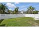 Spacious backyard surrounded by a white fence, lush green grass, and tall palm trees at 212 Ficus St, Celebration, FL 34747