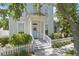 Charming two-story home featuring a welcoming front porch, blue door, and a well-maintained picket fence at 212 Ficus St, Celebration, FL 34747
