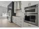 This updated kitchen features stainless steel appliances, stone countertops, and white custom cabinets at 212 Ficus St, Celebration, FL 34747