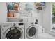 Laundry room features washer, dryer, overhead shelving, and bright window at 212 Ficus St, Celebration, FL 34747