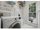 Bright laundry room with front load washer and dryer, and a view to the outside at 212 Ficus St, Celebration, FL 34747