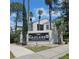The Cascades Condominiums sign with lush landscaping and palm trees on a sunny day at 2130 Cascades Blvd # 108, Kissimmee, FL 34741