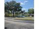 Scenic pond with fountain, framed by mature trees, gazebo, and white fencing on a sunny day at 2130 Cascades Blvd # 108, Kissimmee, FL 34741