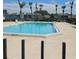The community pool is surrounded by lounge chairs and palm trees on a sunny day at 2130 Cascades Blvd # 108, Kissimmee, FL 34741