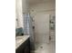 A bathroom featuring a shower, granite countertops and storage shelving at 219 Duke Dr, Deland, FL 32724