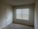 A minimalist bedroom is brightened by the window and includes neutral carpet flooring at 219 Duke Dr, Deland, FL 32724