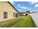 Backyard featuring green lawn, a storage shed, and white fencing at 2289 Jessica Ln, Kissimmee, FL 34744