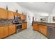 Modern kitchen with oak cabinetry, granite countertops, stainless steel appliances, and tile backsplash at 2289 Jessica Ln, Kissimmee, FL 34744