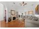 Bright living room featuring a fireplace, ceiling fan, hardwood floors, and comfortable sofas at 2289 Jessica Ln, Kissimmee, FL 34744