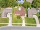 Aerial view of a charming single-Gathering home with a brown roof, fenced backyard, and lush landscaping at 2430 Mill Run Blvd, Kissimmee, FL 34744