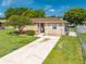Well-kept home featuring a neatly landscaped front yard, driveway, and inviting exterior with mature trees at 2430 Mill Run Blvd, Kissimmee, FL 34744