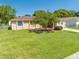 Inviting home with beautiful landscaping, manicured lawn, and welcoming entrance enhanced by mature shade tree at 2430 Mill Run Blvd, Kissimmee, FL 34744
