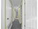 Well-lit hallway with carpet flooring and white doors leading to various rooms at 2430 Mill Run Blvd, Kissimmee, FL 34744
