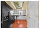 Galley-style kitchen featuring black appliances, wood floors, and white cabinetry at 2430 Mill Run Blvd, Kissimmee, FL 34744