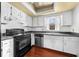 Well-lit kitchen with black appliances, wood floors, and white cabinetry at 2430 Mill Run Blvd, Kissimmee, FL 34744