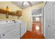 Laundry room features wood floors, washer, dryer, and entrance to the living room at 2430 Mill Run Blvd, Kissimmee, FL 34744