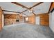 Spacious living room featuring a stone fireplace, wood-paneled walls, and ceiling beams at 2430 Mill Run Blvd, Kissimmee, FL 34744