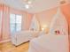 Charming pink bedroom with twin beds, sheer canopy, and a window with sheer curtains at 2611 Gala N Rd # 101, Kissimmee, FL 34746
