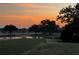 Scenic golf course view at sunrise with a pond, lush green grass and mature trees at 2615 Autumn Green Dr, Orlando, FL 32822