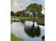 Picturesque view of a pond on the golf course with a tree reflecting on the water at 2615 Autumn Green Dr, Orlando, FL 32822