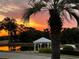 Picturesque pond view with a gazebo and colorful sunset reflected in the water at 2615 Autumn Green Dr, Orlando, FL 32822